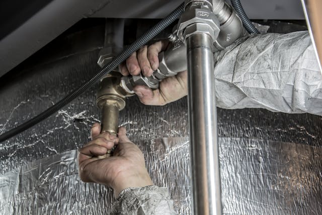 Close-up of a plumber checking the pipes