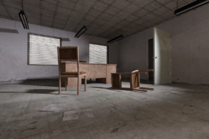 A badly maintained property with old chairs and a desk