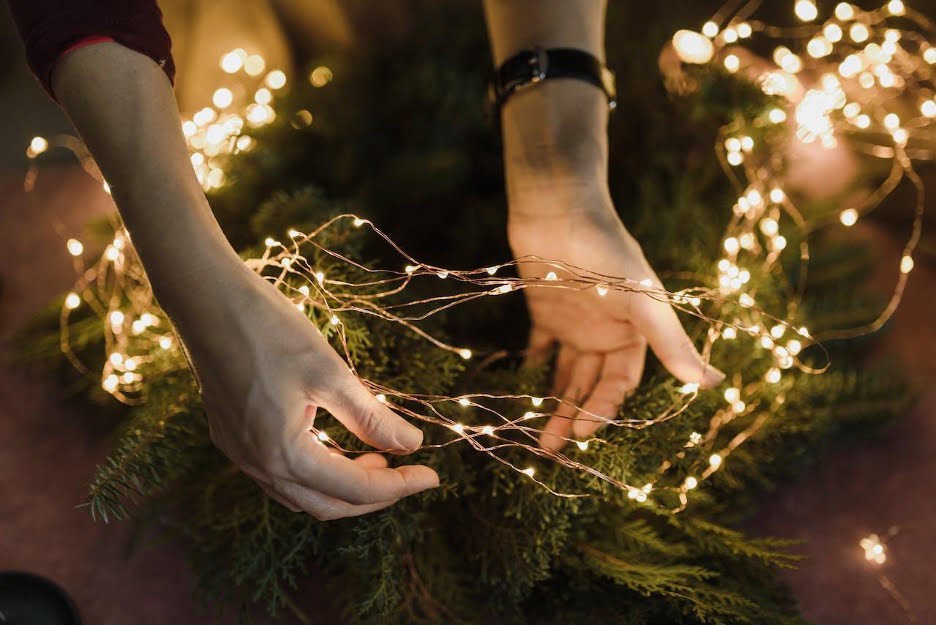 A person holding string lights.