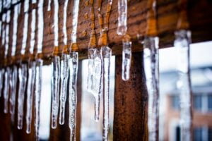 Icicles on the inside of a wooden window seal, one of the ways snowmelt can lead to costly water damage